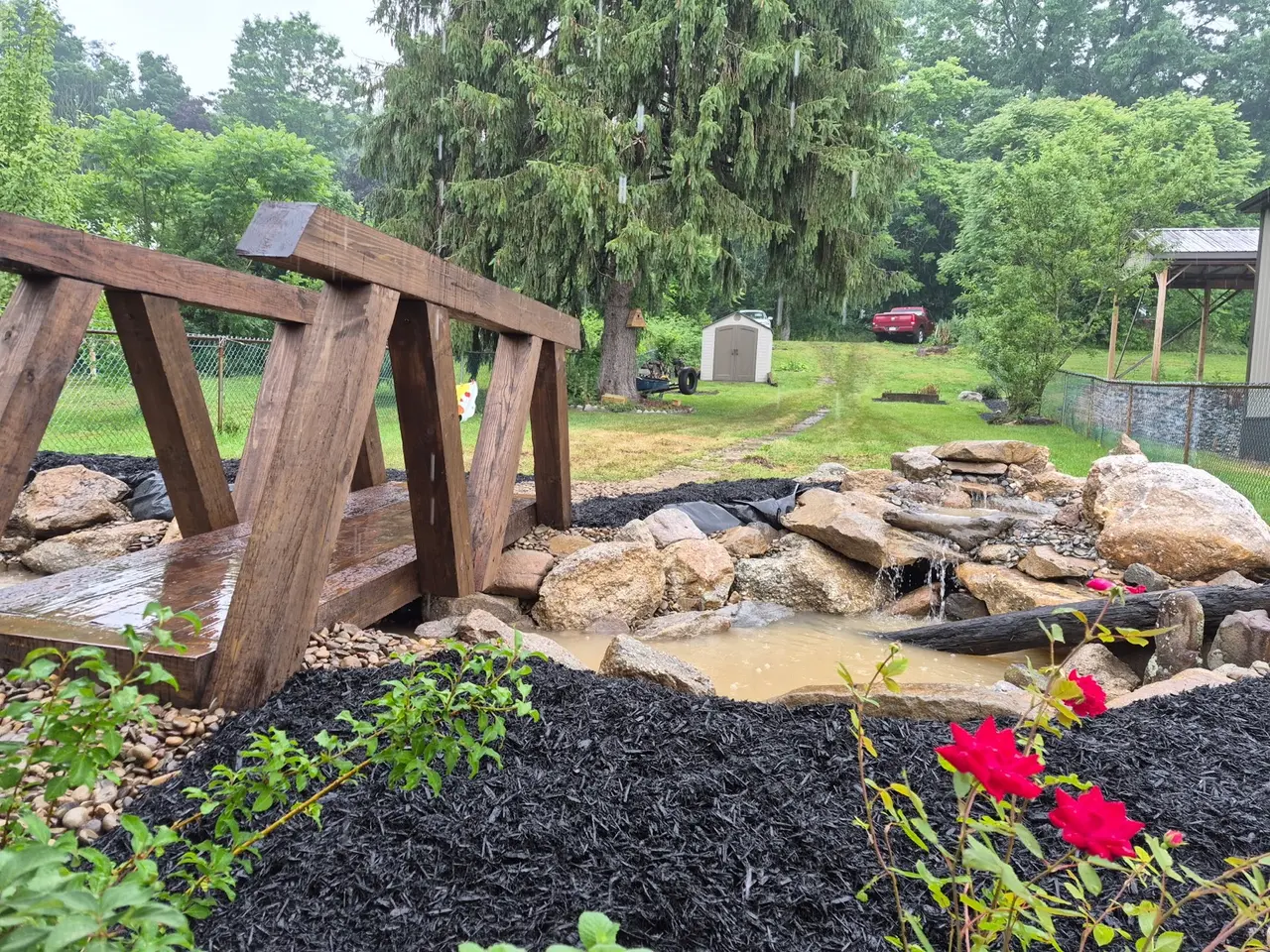 Rock water feature under construction beside a timber footbridge