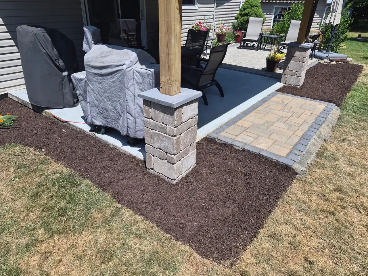 Masonry column and bordered paver landing at a covered porch
